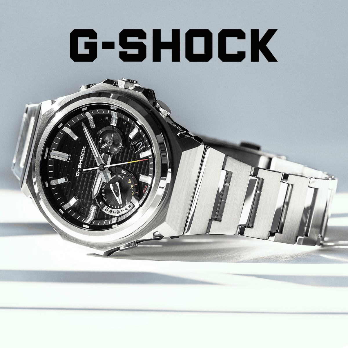 Metal G-Shock on a cold-toned white and grey background and a black G-Shock logo