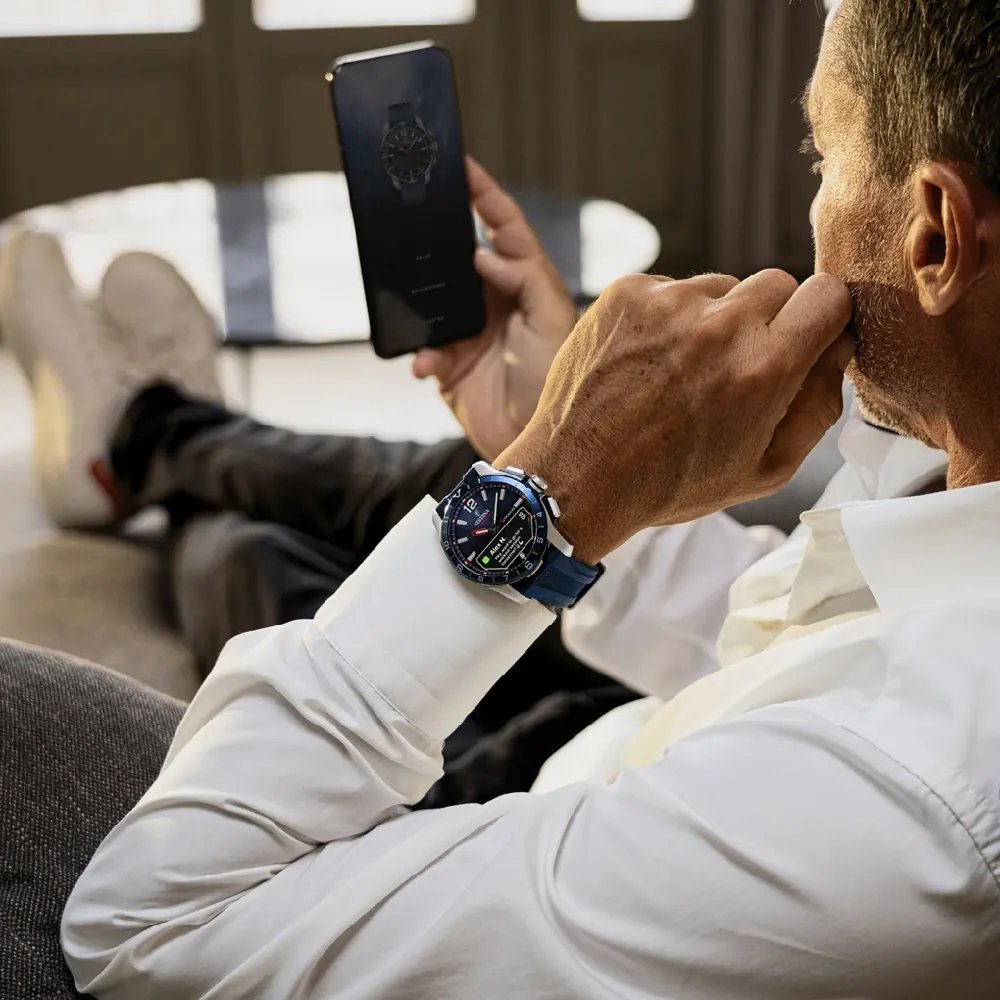 A man wearing a hybrid festina watch looking at the app on his smartphone