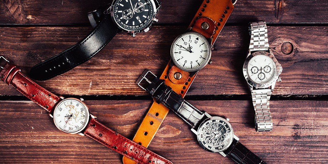 una collezione di orologi su un tavolo di legno
