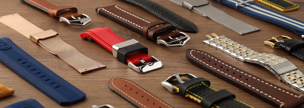 A collection of watch bands on a wooden table