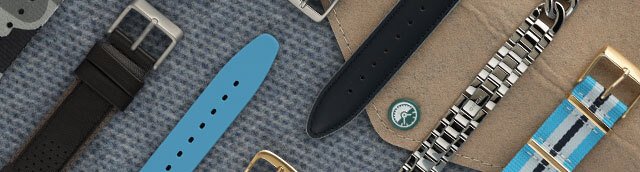 Correas sobre una mesa de madera con un poco de verde pino