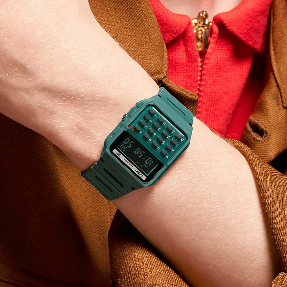 Close up of a wrist wearing a green casio calculator watch