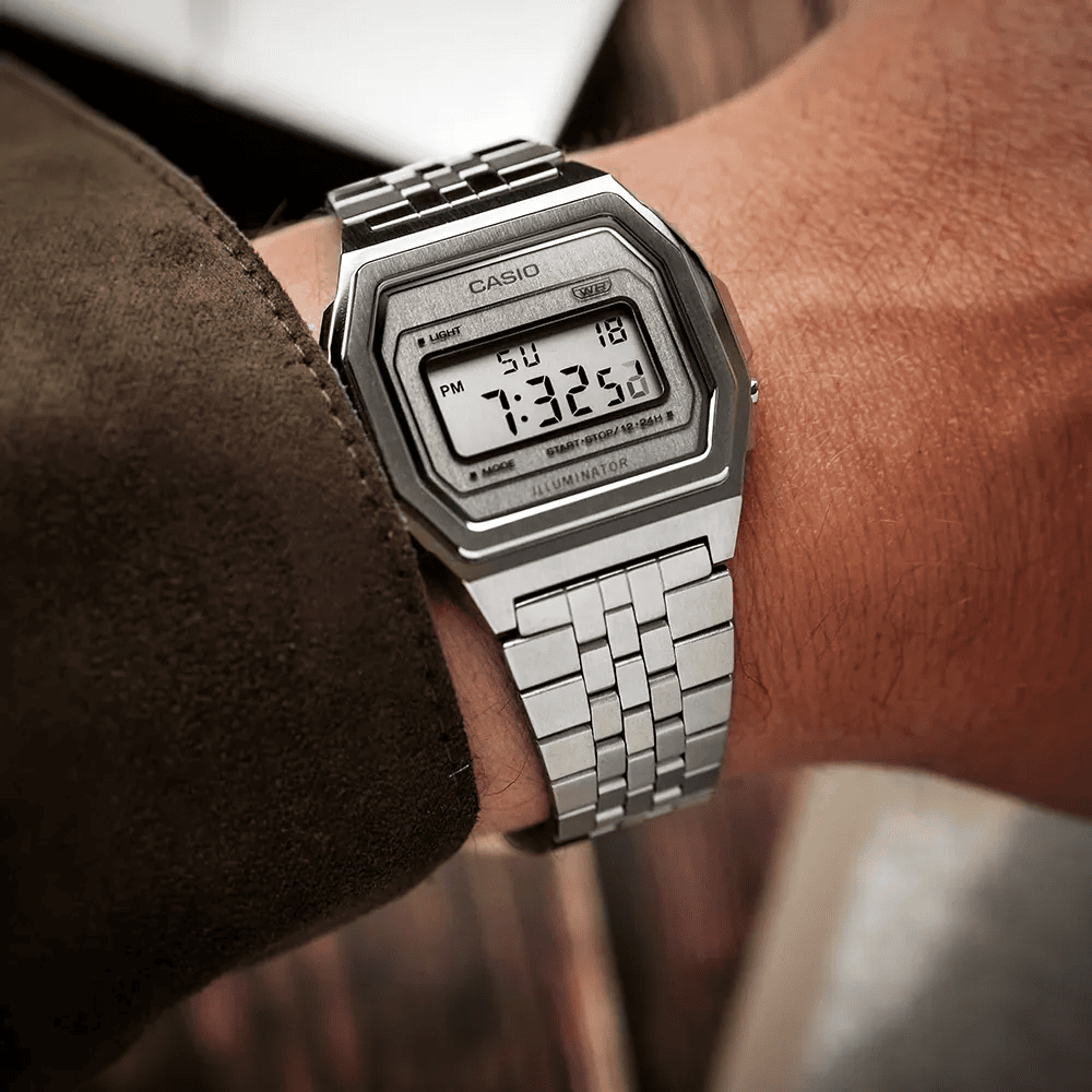 le poignet d’un homme portant une montre vintage Casio argentée