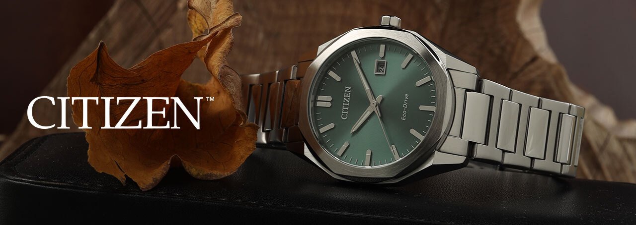 Steel Citizen watch with green dial on a block of wood