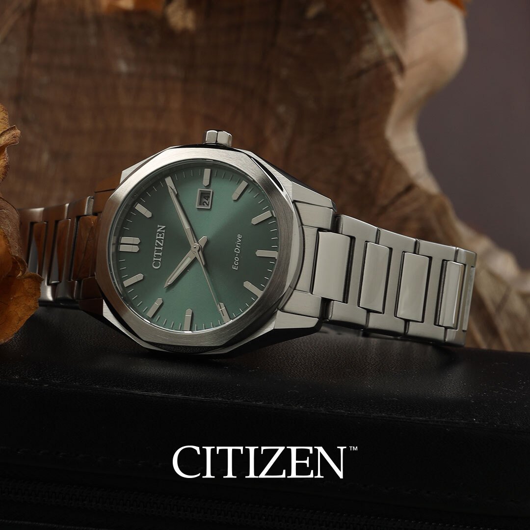 Steel Citizen watch with green dial on a block of wood