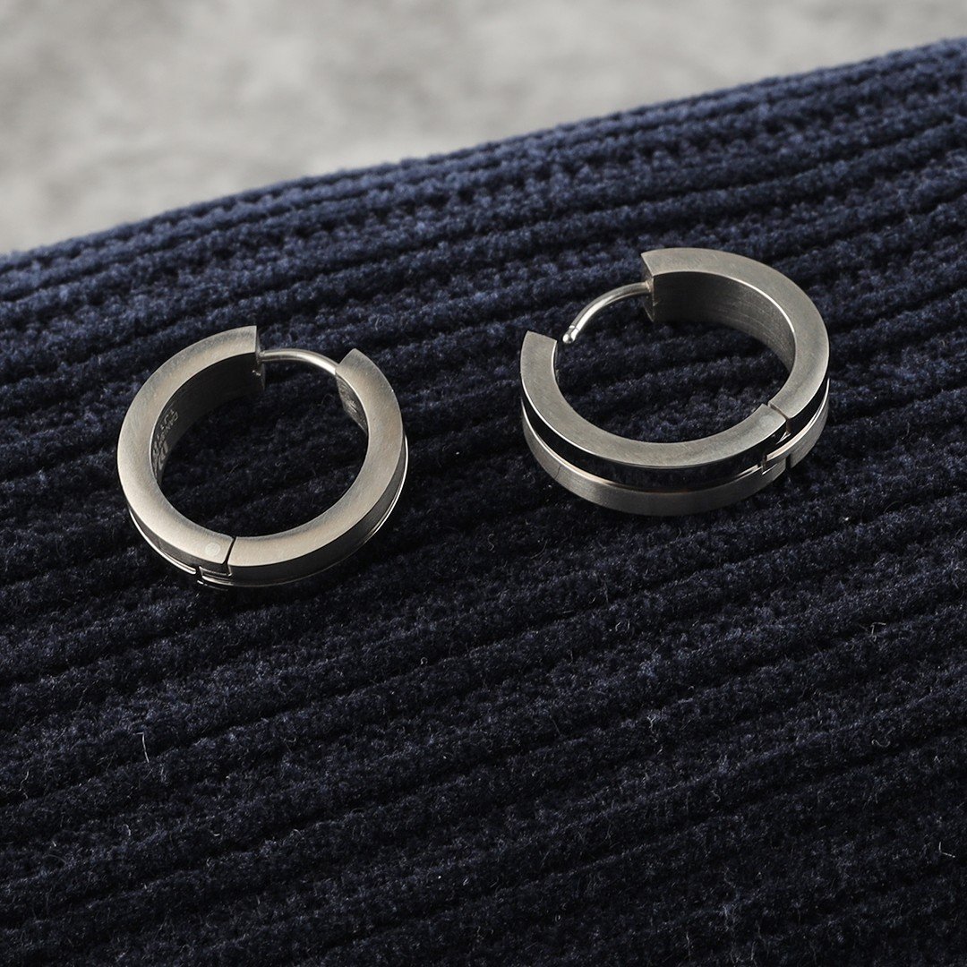 2 boucles d'oreilles en argent sur un coussin bleu