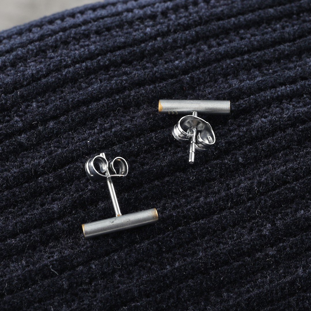 2 boucles d'oreilles en argent sur un coussin bleu