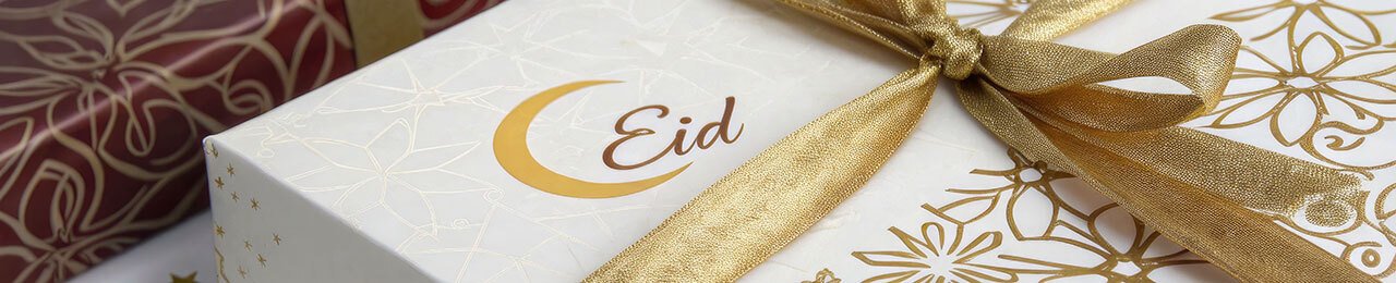 zwei wunderschön verpackte Geschenke mit der Aufschrift Eid und einer Mondsichel in Gold