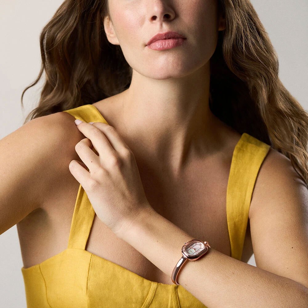 Close up of a woman wearing a fossil bracelet watch