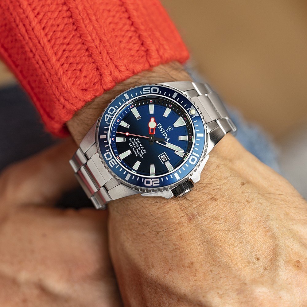 Man wearing a festina diving watch and a bright orange sweater