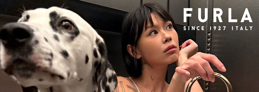 Close up of a dalmatian dog face with a girl in the background and the Furla logo