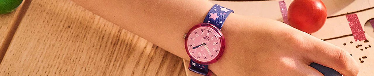 O pulso de uma criança com um relógio roxo