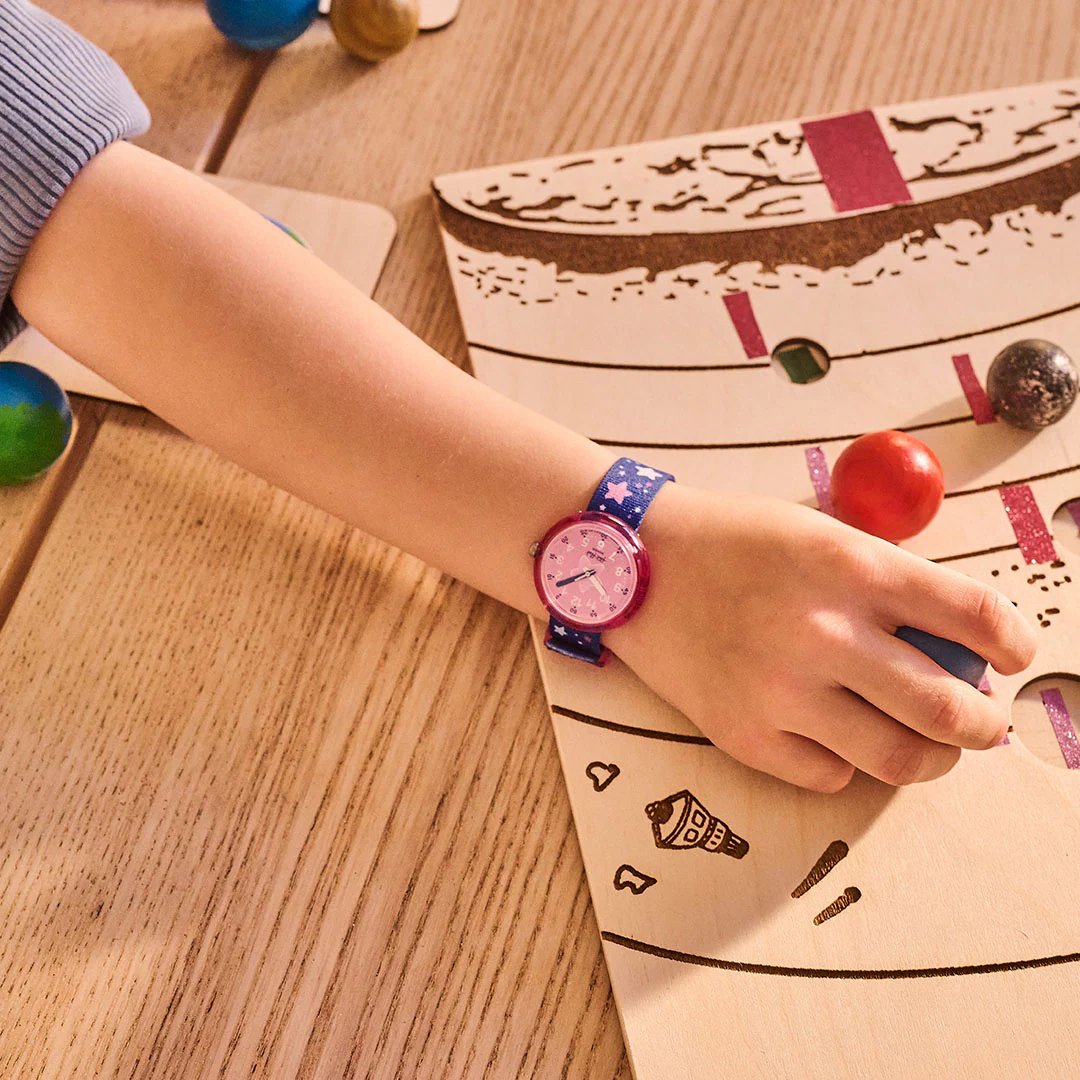 A child's arm holding a ball on a drawing