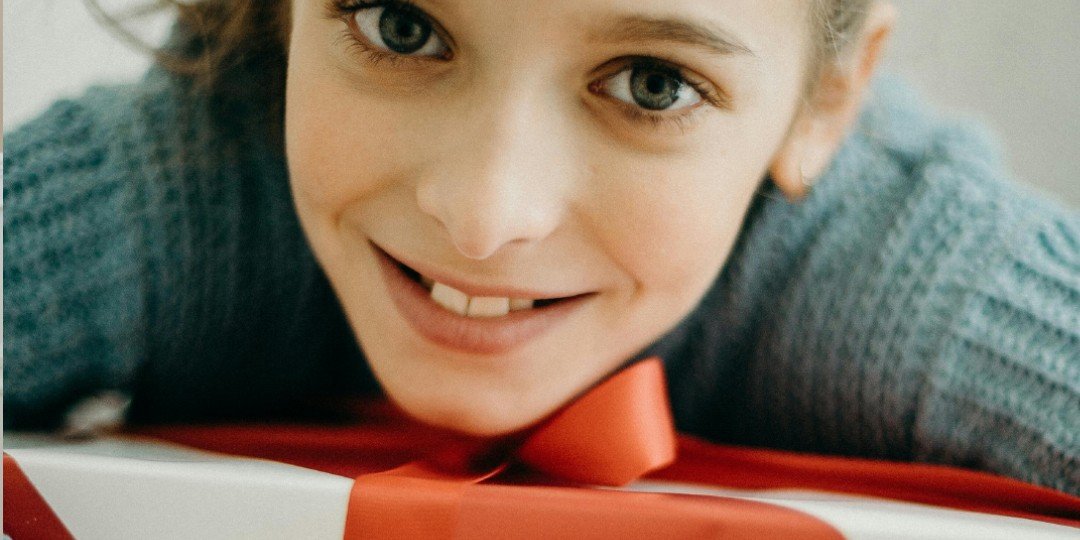 enfant trouvant un cadeau sous le sapin