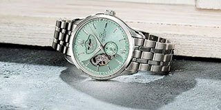 Four Orient Star watches on a dark sky background