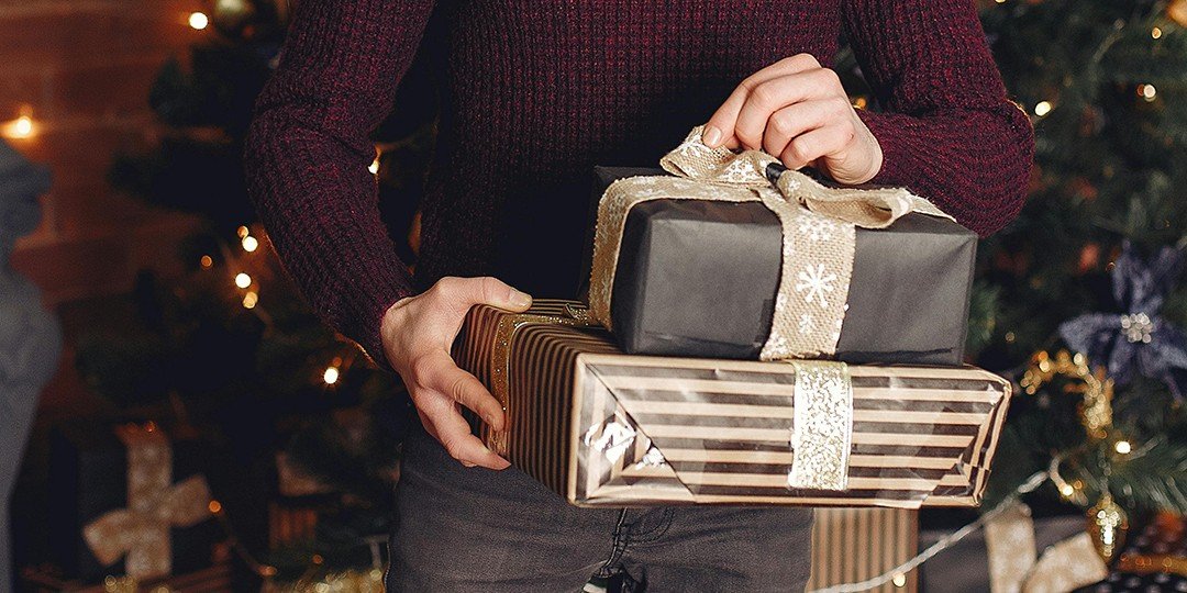 close up of a man's hands holding xmas gifts