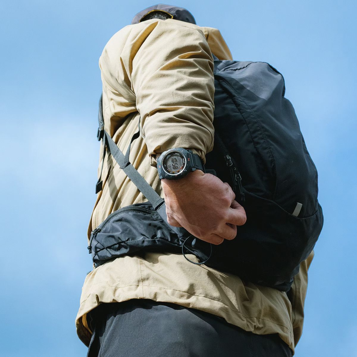 Man wearing an outdoor jacket, backpack and PRG-69 watch