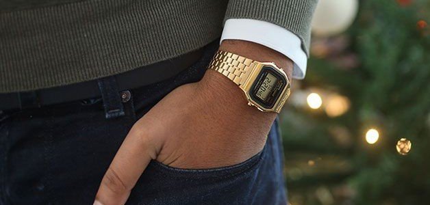 la main d'un homme dans la poche de son jean portant une montre casio en or