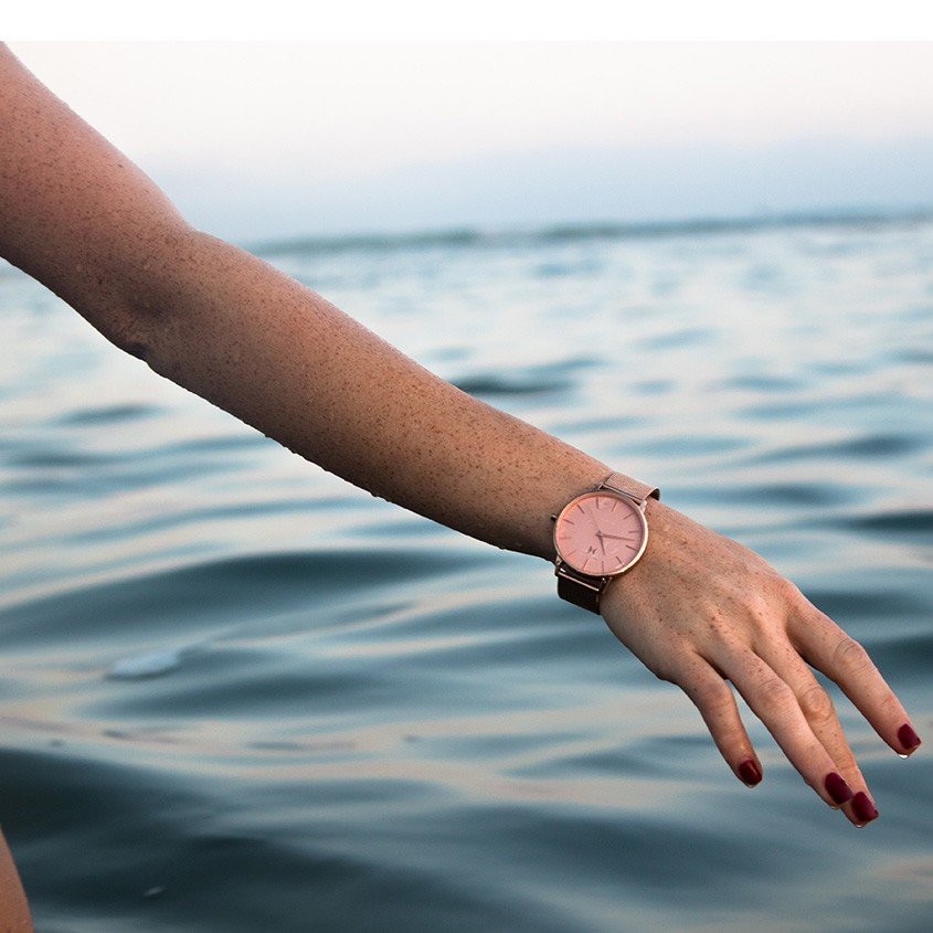 vrouw met horloge in zee