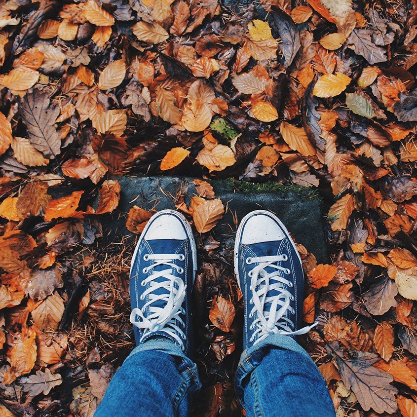 blauwe gympen en herfstbladeren