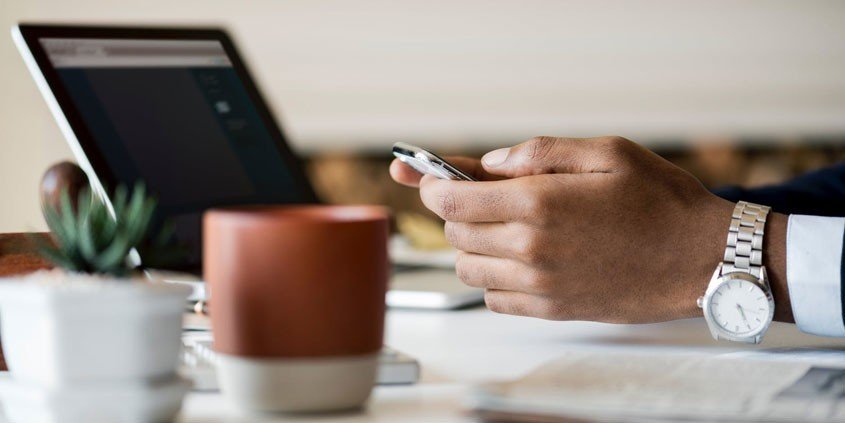 Mann mit Laptop und Smartphone