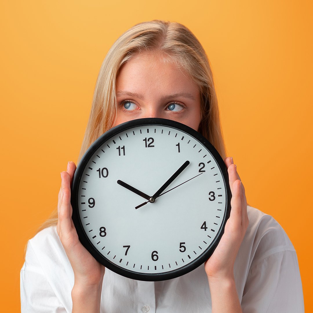 Teenage girl holding a clock