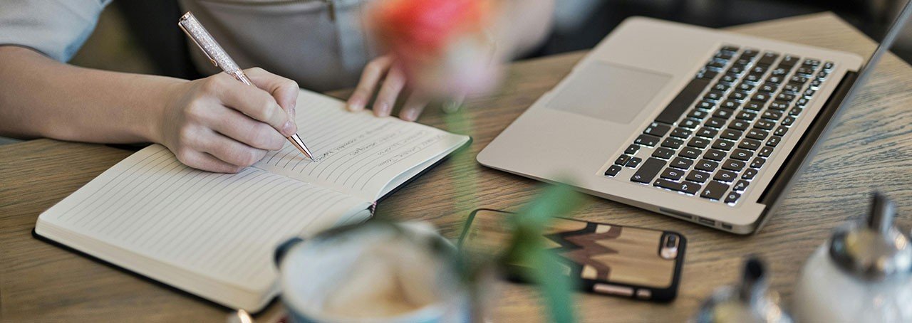 mujer escribiendo en su escritorio