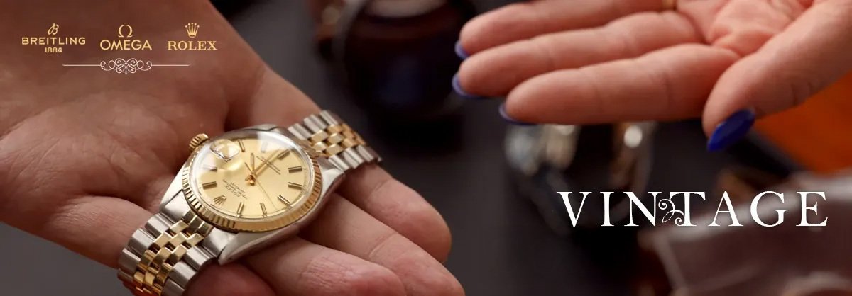 Man holding a rolex watch and a woman's hand reaching for the watch