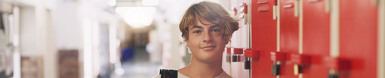 Blonder Teenager in einem Schulflur